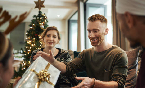 Shot of young friends opening their Christmas gifts together at home