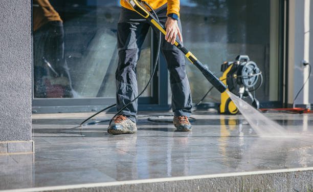 Man cleaning the terrace with high pressure cleaner on beautiful sunny day.